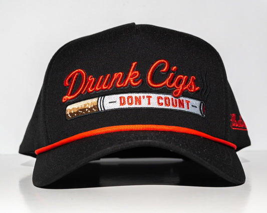 A black baseball cap with orange embroidered text reading 'Drunk Cigs' and a graphic that says 'DON'T COUNT' across the front, shown against a plain light background.